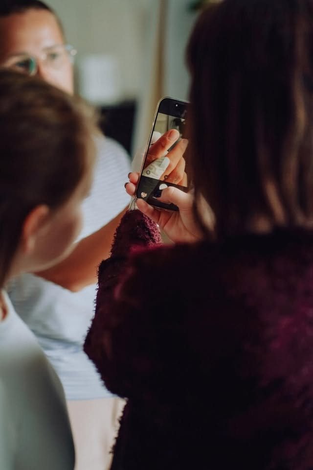Kursantka dokumentująca efekty stylizacji telefonem